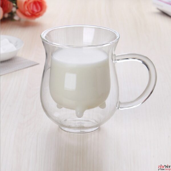 כוס עם זכוכית פנימית בצורת עטינים מלאה בחלב על שולחן